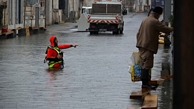 A rescue worker stands in a flooded street of Saintes as severe flooding hits western France amid storm Pedro, Wednesday, Feb. 18, 2026.