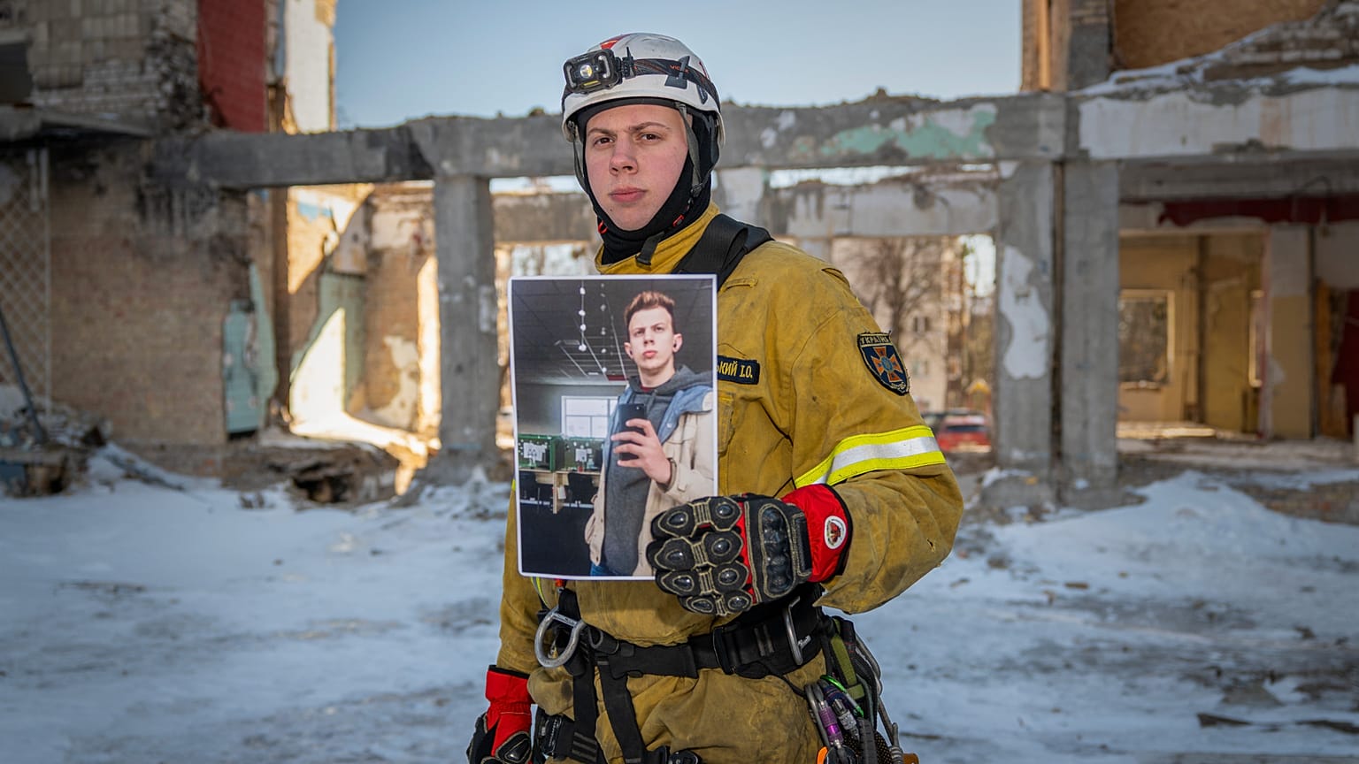Ivan Khmelnytskyi, de 25 años, un trabajador de rescate, posa con una fotografía de él mismo trabajando en un centro de llamadas antes de la invasión a gran escala de Rusia.