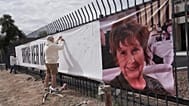 Jeff Robb, a Seattle resident wintering in Tucson, signs a banner supporting Nancy Guthrie in Tucson Ariz., on Friday, Feb. 13, 2026. 