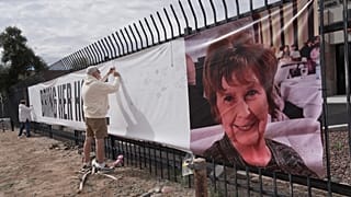 Jeff Robb, a Seattle resident wintering in Tucson, signs a banner supporting Nancy Guthrie in Tucson Ariz., on Friday, Feb. 13, 2026. 