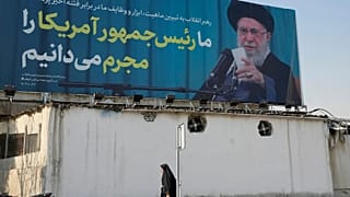  امرأة تمر أمام لوحة إعلانية تحمل صورة المرشد الأعلى الإيراني آية الله علي خامنئي مع اقتباس له يقول: "نعترف بأن رئيس أمريكا مجرم"، في طهران، إيران، الثلاثاء 17 فبراير 2026. 