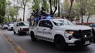 Guardias Nacionales escoltan una ambulancia a la sede de la Procuraduría General de la República en la Ciudad de México el domingo 22 de febrero.