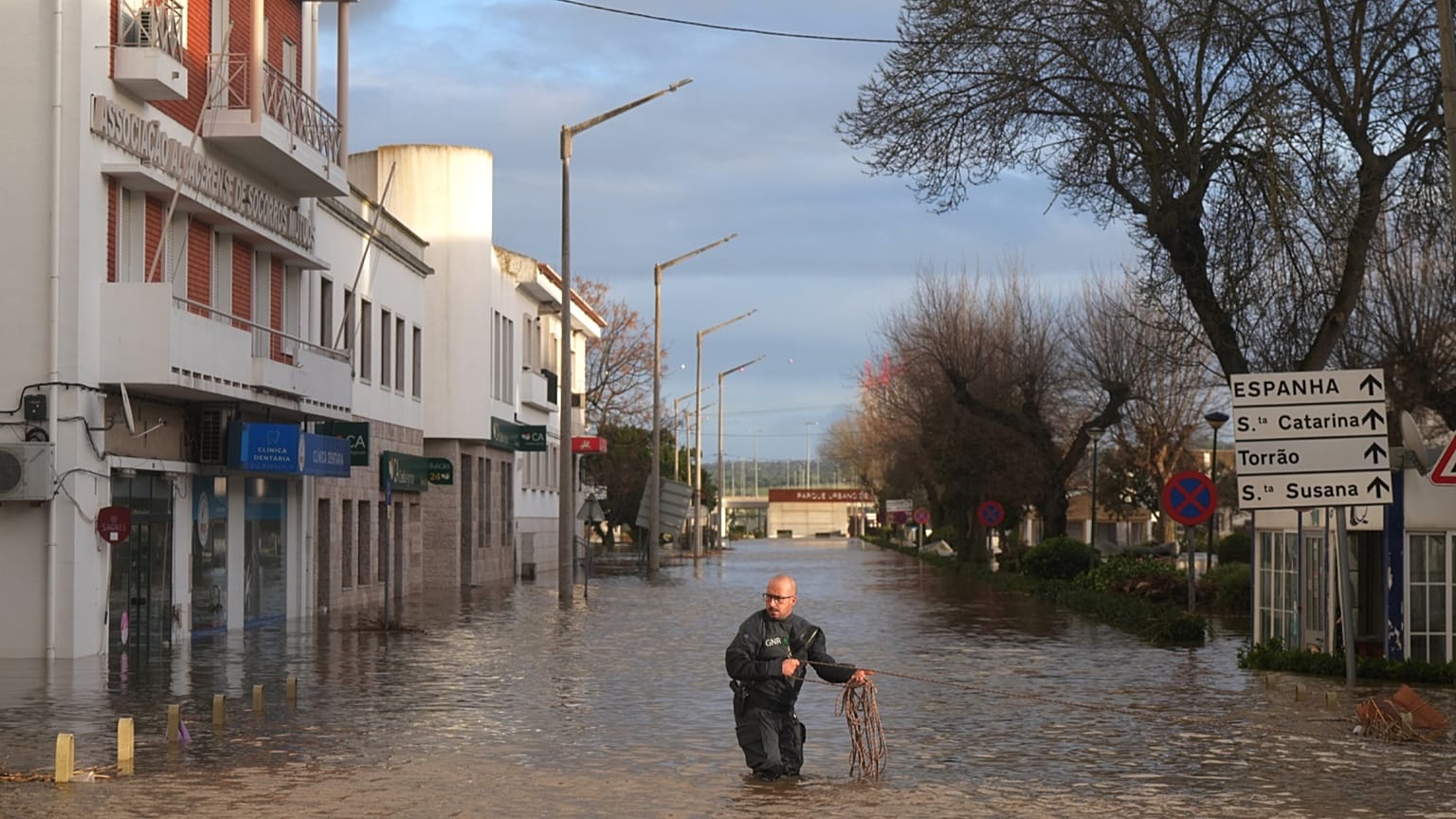 Polícias retiram moradores de um hotel de barco insuflável numa rua inundada, após a cheia do rio Sado devido a fortes chuvas em Alcácer do Sal