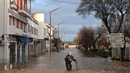 Police officers evacuate residents from a hotel by inflatable boat along a flooded street after the Sado River overflowed following heavy rains in Alcácer do Sal.