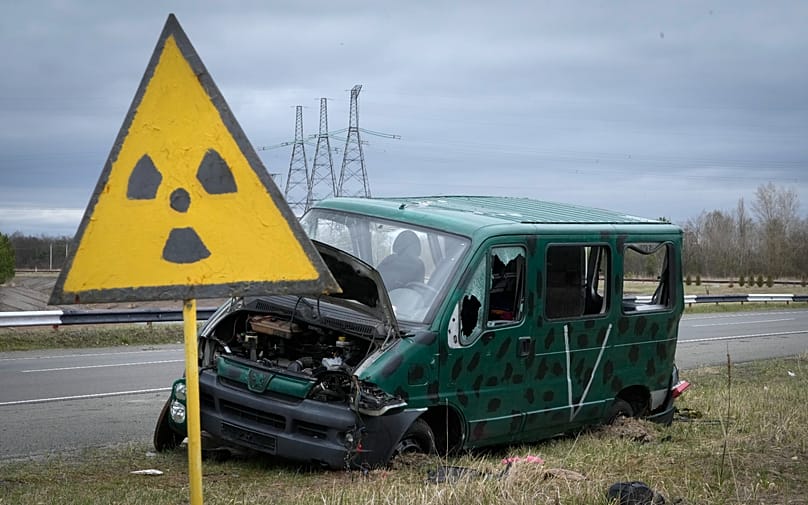 FILE - A radiation sign is seen near a broken Russian vehicle close to the Chernobyl nuclear power plant in Chernobyl, Ukraine, April 16, 2022.