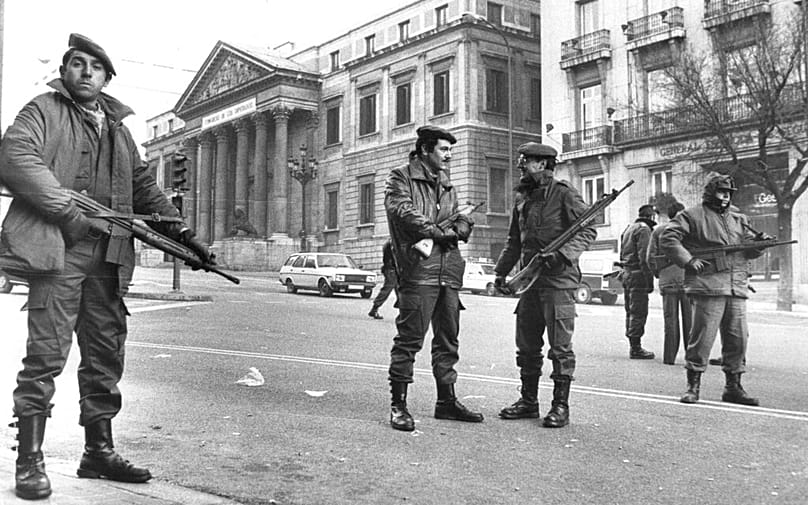 Members of the the antiriot squad of the national police stand guard at the square in front of the Spanish parliament seen in the background, in Madrid, February 1981