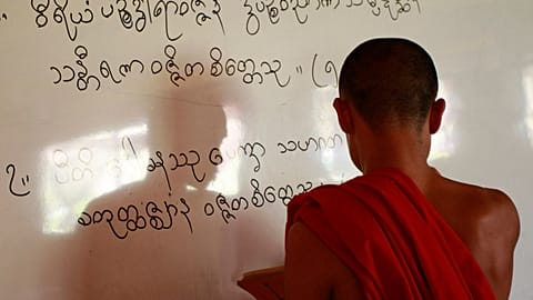 In questa foto, scattata giovedì 19 gennaio 2012, un monaco buddista karen scrive caratteri karen su una lavagna mentre tiene lezione in classe.