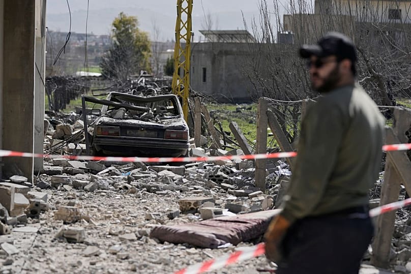 رجل يقف بالقرب من مبنى دمره غارة إسرائيلية في قرية تمنين شرقي لبنان، السبت 21 فبراير/شباط 2026. 