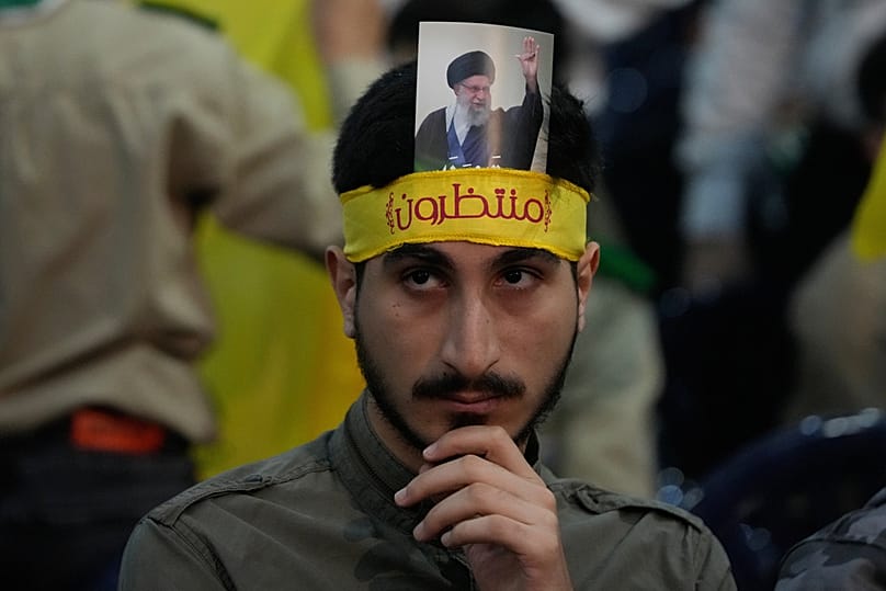 يرتدي أحد أنصار حزب الله عصابة ويحمل صورة للمرشد الأعلى الإيراني علي خامنئي، لبنان، يوم الاثنين 26 يناير/كانون الثاني 2026