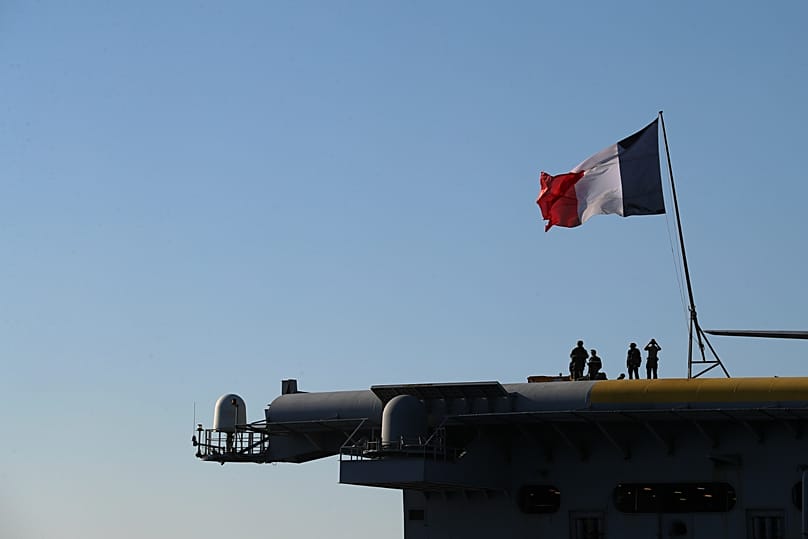 Des officiers de la marine française se tiennent à bord du porte-avions Charles de Gaulle, au large de la banlieue de Faliro, à Athènes, en 2022
