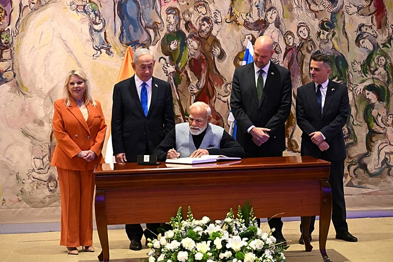  رئيس الوزراء الإسرائيلي بنيامين نتنياهو وزوجته سارة يشاهدان رئيس الوزراء الهندي ناريندرا مودي وهو يوقع في سجل الزوار في قاعة شاغال في الكنيست، البرلمان الإسرائيلي،