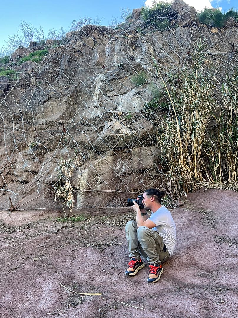 Γύρισμα δίπλα σε ένα μεταλλικό δίχτυ συγκράτησης από πέτρες.