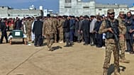 A soldier stands guard as army officials and others attend a funeral prayer of an army officer, who was killed in a suicide bombing in Bannu, Mansehra, Pakistan, 22 Feb. 2026