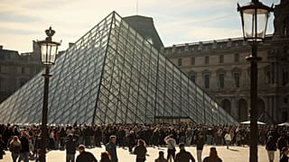 Ludzie zwiedzają dziedziniec paryskiego Luwru, środa 25 lutego 2026 r. (AP Photo/Thomas Padilla)