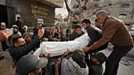 Mourners carry the bodies of two members of Hamas who were killed in an Israeli military strike, at Shifa Hospital in Gaza City