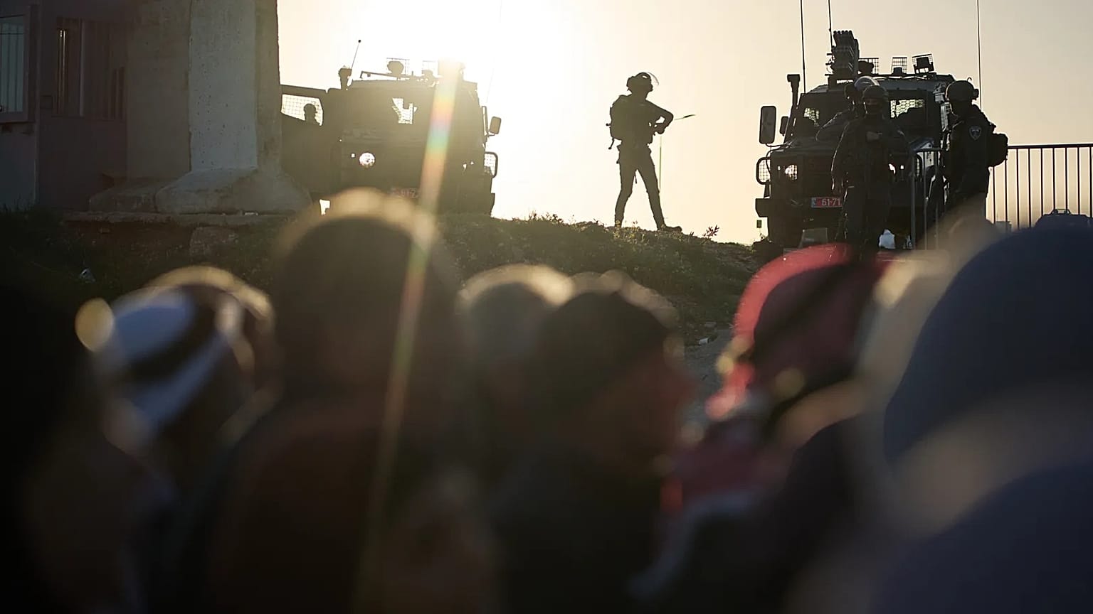 جنود إسرائيليون يقفون حراساً بينما يصطف المصلون الفلسطينيون لعبور حاجز قلنديا العسكري الإسرائيلي بين مدينة رام الله في الضفة الغربية والقدس في طريقهم لأداء صلاة الجمعة في المس