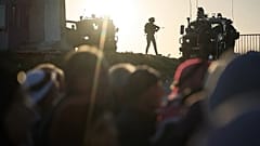جنود إسرائيليون يقفون حراساً بينما يصطف المصلون الفلسطينيون لعبور حاجز قلنديا العسكري الإسرائيلي بين مدينة رام الله في الضفة الغربية والقدس في طريقهم لأداء صلاة الجمعة في المس