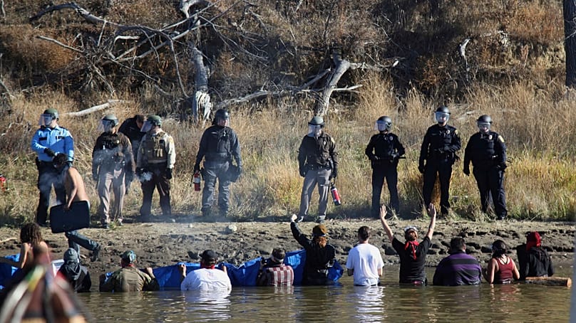 FILE - Protesters confront local police as they demonstrate against the expansion of the Dakota Access Pipeline, near Cannon Ball, N.D., Nov. 2, 2016.