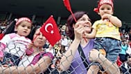 Turkish mothers hold their baby watching the celebrations of the National Sovereignty and Children's Festival  in 2008 in Ankara.