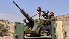 Taliban-Kämpfer blicken nach oben, während sie einen bewaffneten Pickup auf der afghanischen Seite des Ghulam-Khan-Übergangs zu Pakistan in der Provinz Khost, Afghanistan, bemannen, 27. Februar 2026