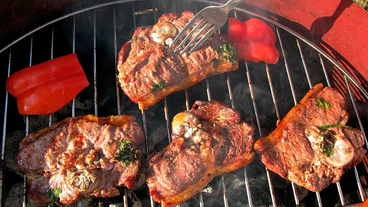 File - Meat and red pepper lay on the grill of a barbecue in Cologne, Germany. 5 Aug. 2009
