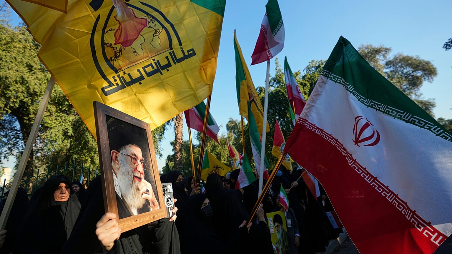 تجمع محتجون عراقيون أمام السفارة الإيرانية حاملين أعلام إيران، خلال مظاهرة لإظهار التضامن مع إيران ومعارضة التهديدات الأمريكية بشن ضربة عسكرية، في بغداد، العراق