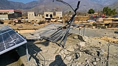 In einem Dorf in Bajaur fällt der Schatten eines Dorfbewohners auf Solarpaneele und Trümmer, die Gefechte zwischen Pakistan und afghanischen Truppen in der Nacht hinterließen.