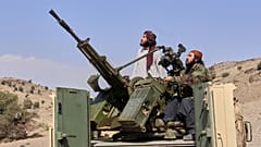 ينظر مقاتلو طالبان إلى الأعلى أثناء قيادتهم شاحنة صغيرة مسلحة على الجانب الأفغاني من معبر غلام خان مع باكستان في ولاية خوست، أفغانستان، الجمعة 27 فبراير 2026. (صورة من وكالة أ