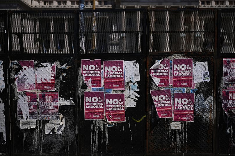 Carteles contra la reforma laboral propuesta por el Gobierno del presidente Javier Milei cubren una valla frente al Congreso en Buenos Aires, el viernes 27 de febrero de 2026.
