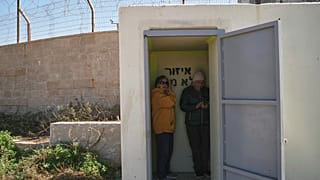 Two women stand inside a shelter after warning sirens sound following Israeli strikes in Iran, in Haifa, northern Israel, Saturday, Feb. 28, 2026