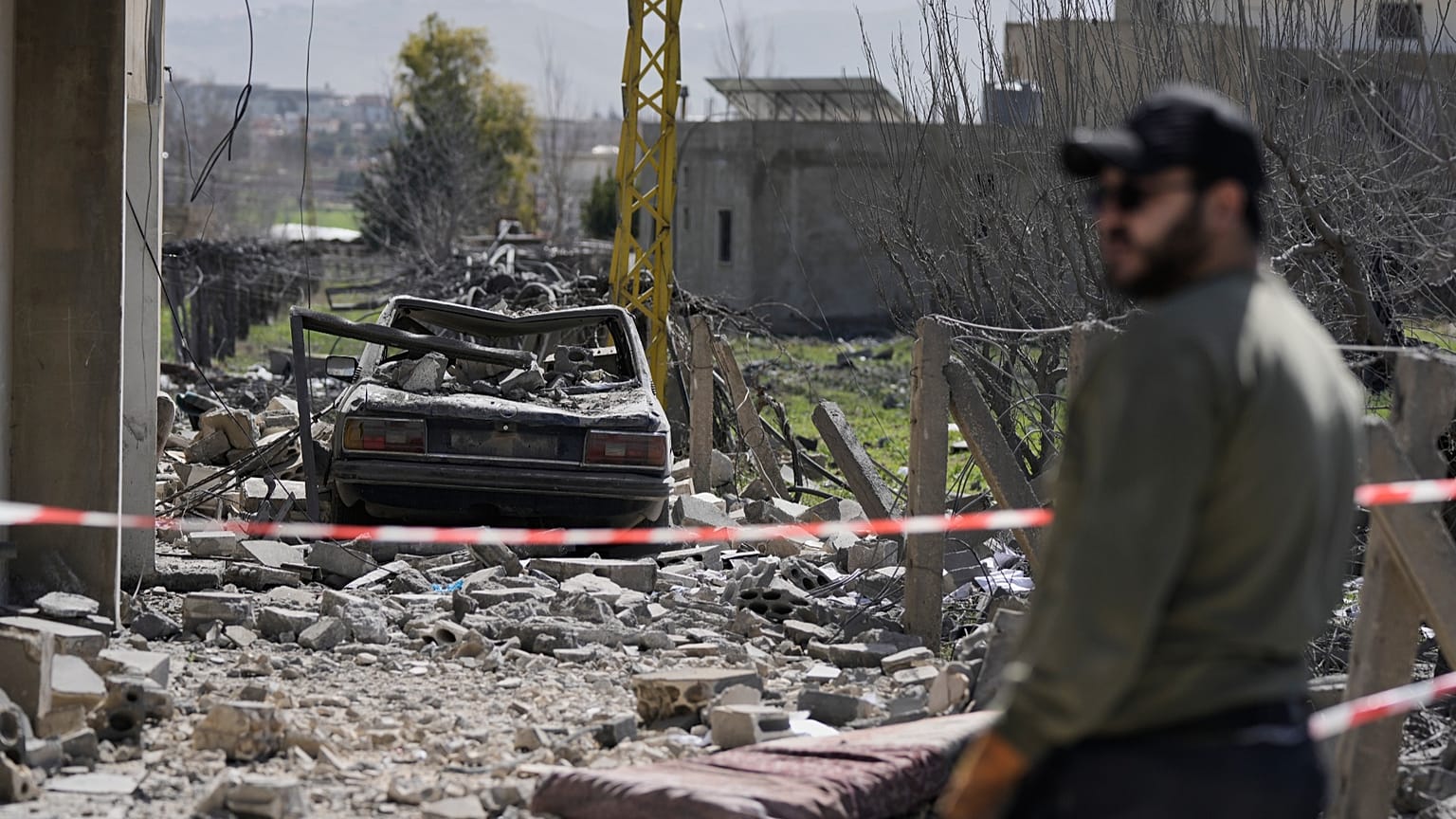 رجل يقف قرب مبنى دمرته غارة إسرائيلية في بلدة تمنين شرق لبنان، في 21 فبراير 2026.