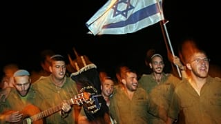 İsrail askerleri, 25 Ekim 2005 Salı günü, Gazze Şeridi'nin hemen dışındaki Kibbutz Nahal Oz yakınlarında düzenlenen Simhat Torah kutlamaları sırasında görüntüleniyor (Arşiv)