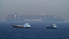 Δύο παραδοσιακά dhows πλέουν δίπλα σε ένα μεγάλο πλοίο μεταφοράς εμπορευματοκιβωτίων στο Στενό του Ορμούζ, 19 Μαΐου 2023. 