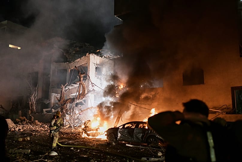 Firefighters try to extinguish flames in a building after a direct hit by an Iranian missile strike in Tel Aviv, Israel, Saturday, Feb. 28, 2026. 