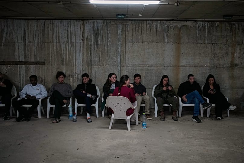 People sits in a shelter after warning sirens sound following Israeli strikes on Iran, in Tel Aviv, Israel, Saturday, Feb. 28