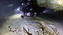 Sualtı arkeoloğu Octavio del Rio, Actun’daki sular altında kalmış mağara sisteminde keşfedilen tarih öncesi bir insan iskeletinin kalıntılarını fotoğraflıyor.
