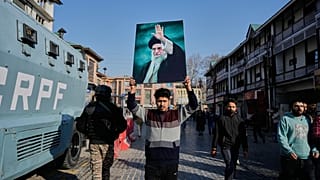 يمسك مسلم شيعي بصورة للمرشد الأعلى الإيراني علي خامنئي خلال احتجاج ضد الولايات المتحدة وإسرائيل