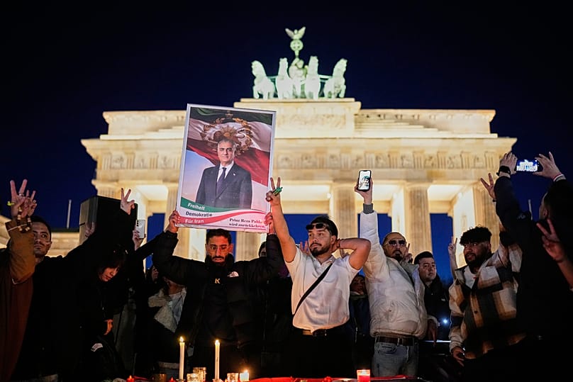 Lors d'un rassemblement à Berlin, un manifestant brandit une affiche du prince héritier iranien en exil Reza Pahlavi. 