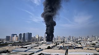 ينبعث عمود أسود من الدخان من أحد المستودعات في المنطقة الصناعية بمدينة الشارقة في دولة الإمارات العربية المتحدة