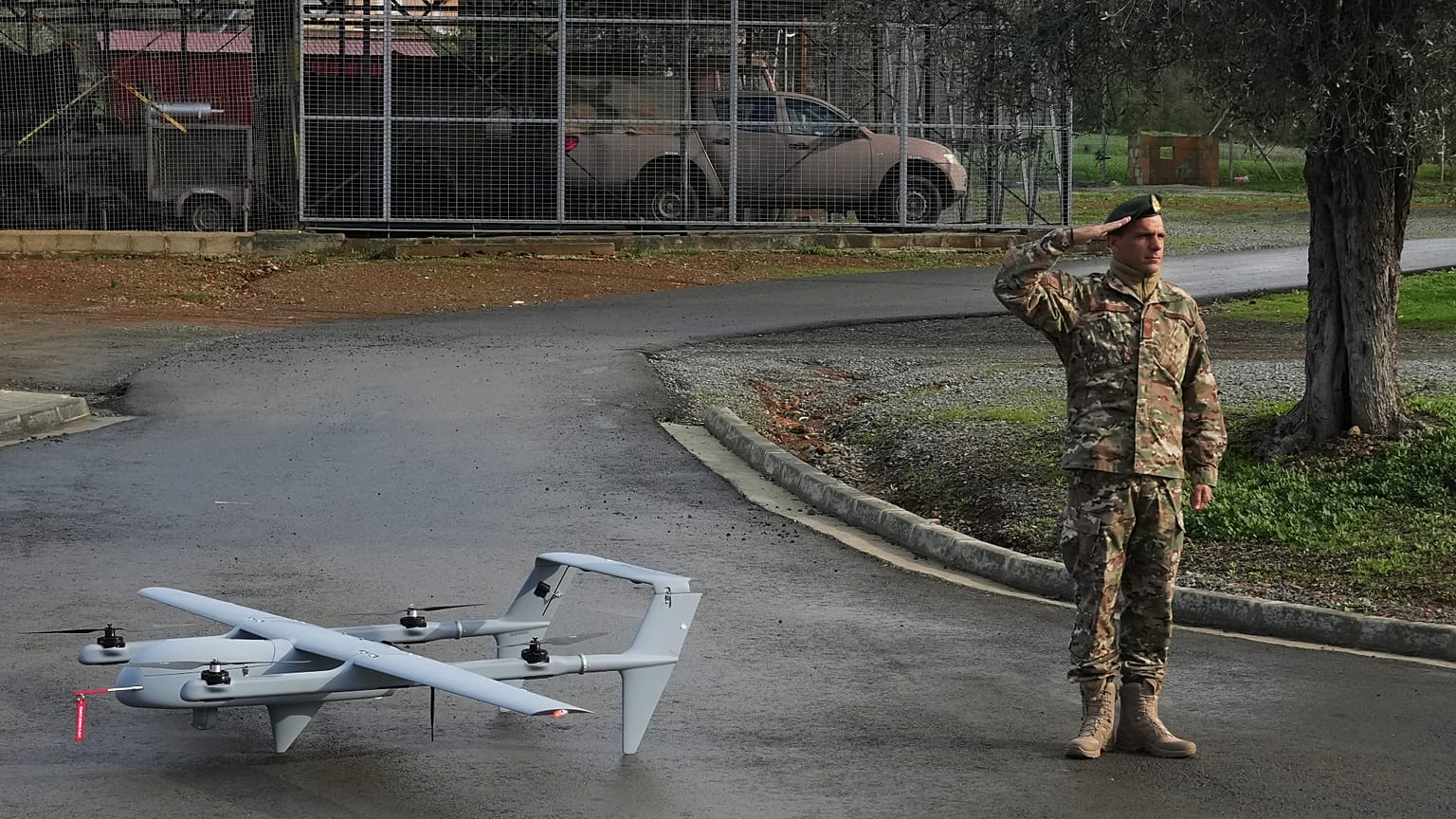 A soldier salutes as he stands next to an H-10 Poseidon drone at a military camp in Mosfiloti village, in the Nicosia district of Cyprus, Monday, Jan. 12, 2026. (AP Photo/Petr