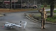 A soldier salutes as he stands next to an H-10 Poseidon drone at a military camp in Mosfiloti village, in the Nicosia district of Cyprus, Monday, Jan. 12, 2026. (AP Photo/Petr
