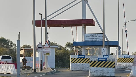 A British soldier stands guards at the main gate of the UK's RAF Akrotiri base after it was hit by a suspected drone strike early morning near Limassol, Cyprus, Monday.