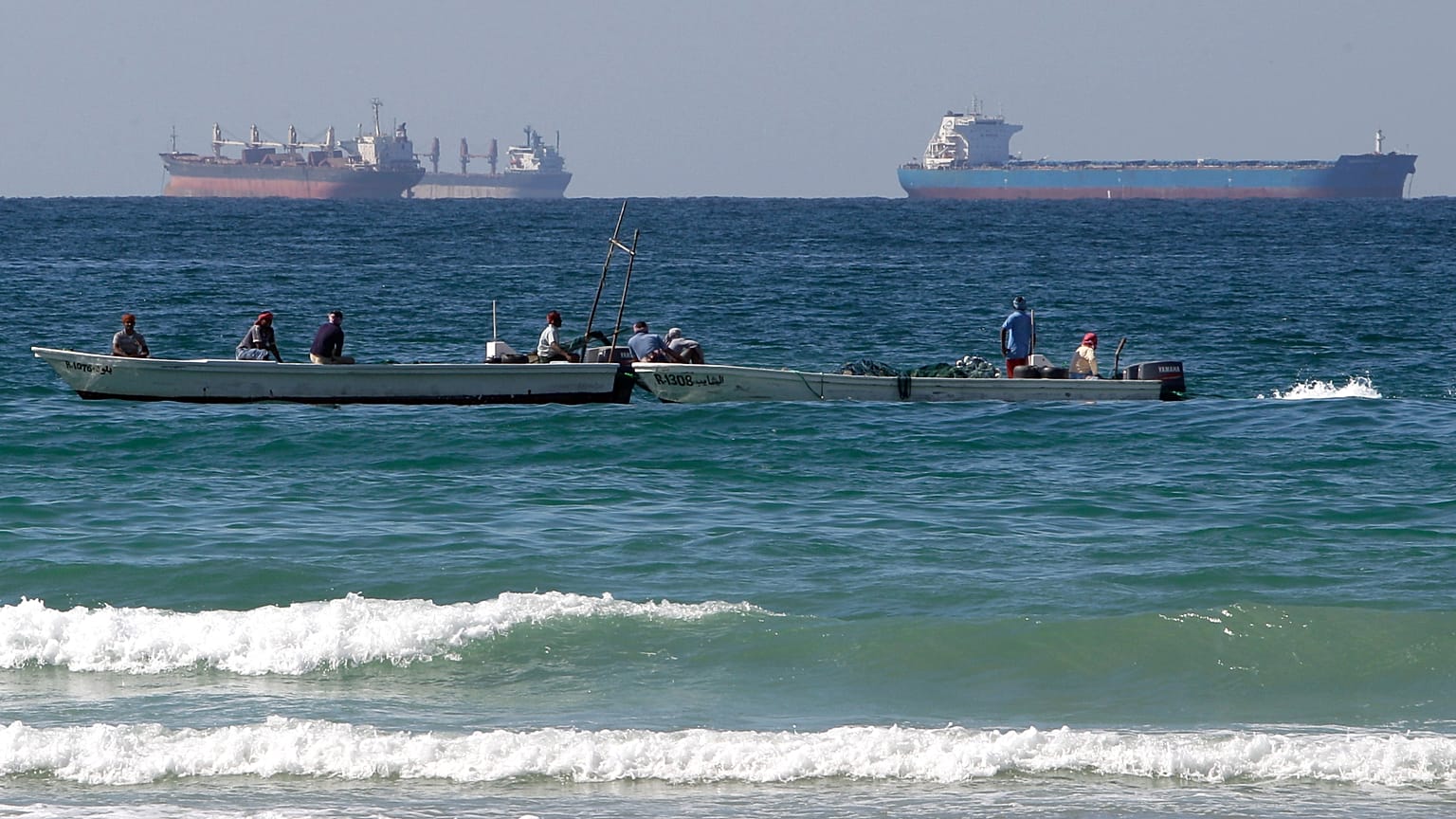 FILE. Fishermen work in front of oil tankers south of the Strait of Hormuz, Jan. 2012