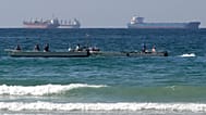 FILE. Fishermen work in front of oil tankers south of the Strait of Hormuz, Jan. 2012