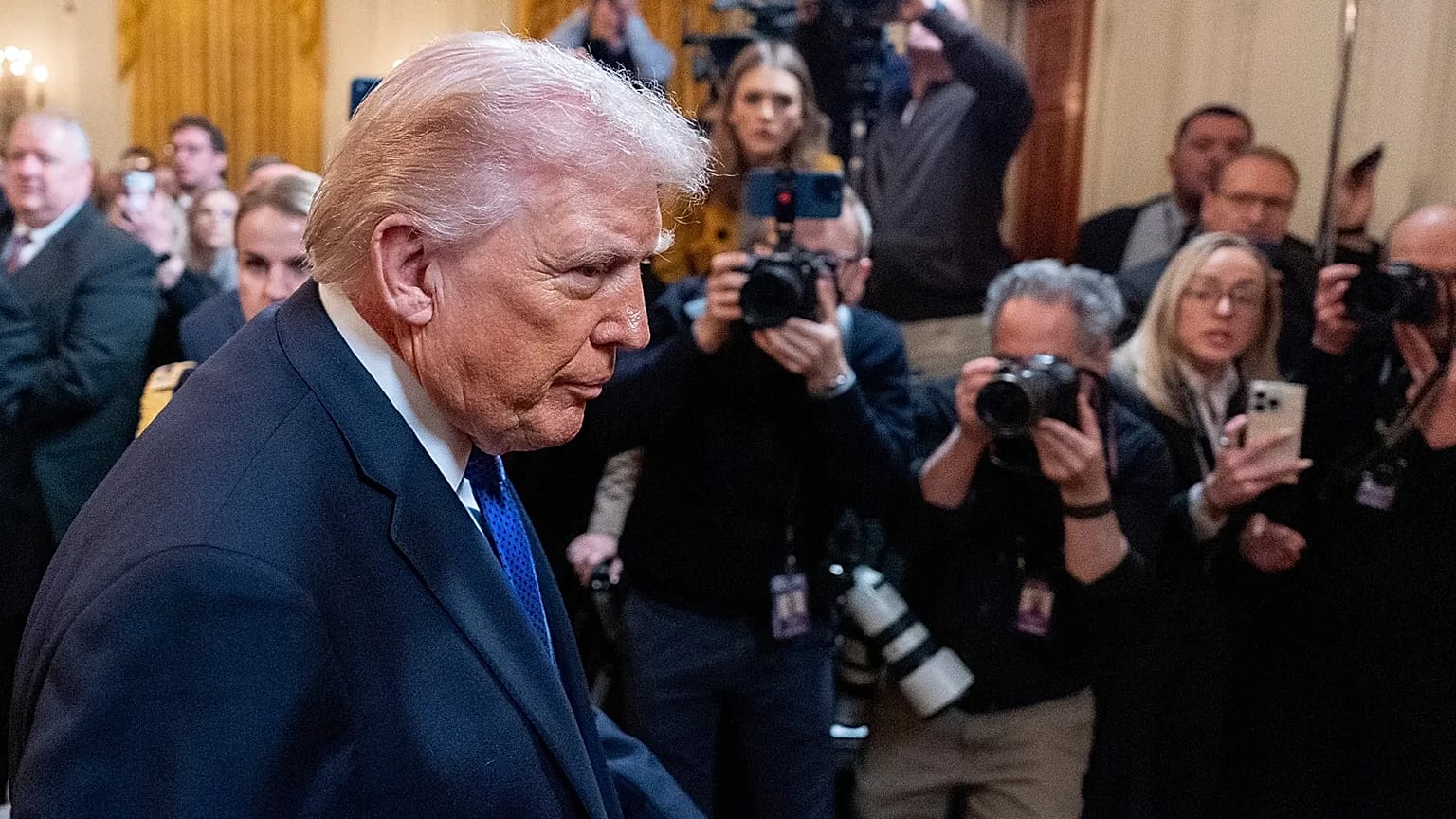 US President Donald Trump passes reporters in the East Room of the White House, 2 March, 2026