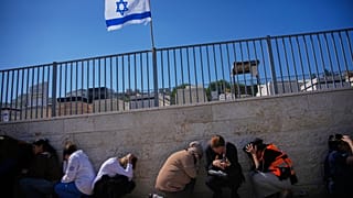 Żałobnicy chowają się, gdy syreny alarmowe ostrzegają przed rakietami wystrzelonymi przez Iran w kierunku Izraela, Izrael, poniedziałek, 2 marca 2026 r. 