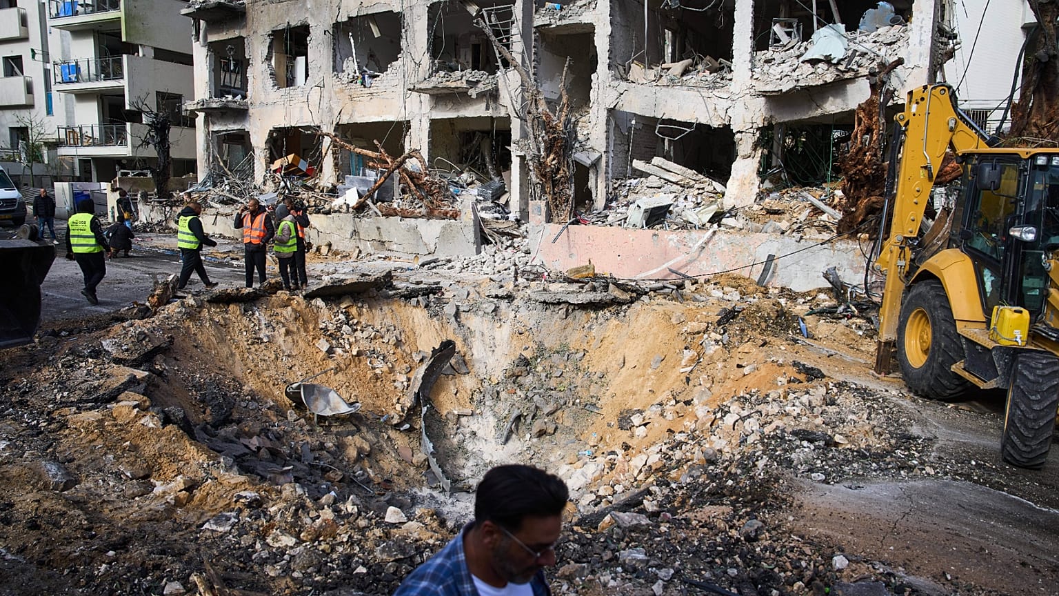 Rescue workers and military personnel survey the scene of a direct hit a day after an Iranian missile struck in Tel Aviv, Israel, Sunday, March 1, 2026.