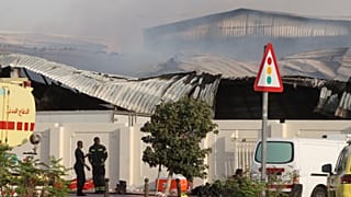 رجال الإطفاء يعملون بينما يتصاعد الدخان خارج مستودع متضرر في منطقة صناعية في الريان بقطر، عقب غارة إيرانية، الأحد 1 مارس 2026.