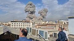 Varios iraníes observan unas columbas de humo en Teherán durante el pasado 28 de febrero