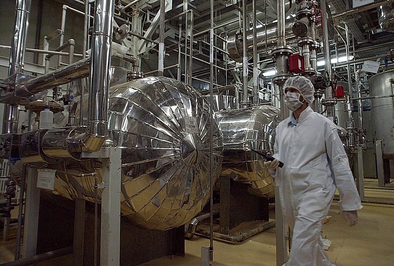 An Iranian security official in protective clothing walks through part of the Uranium Conversion Facility just outside the Iranian city of Isfahan, 30 March, 2005